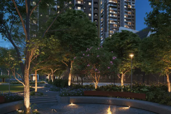 A tree-lined garden court with low lights at dusk below the towers